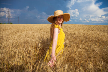 Obraz premium Happy red-haired woman posing in a wheat field