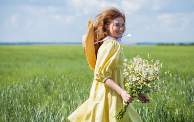 Happy red-haired woman with a bouquet of field daisies