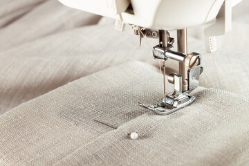 Modern sewing machine presser foot with linen fabric and thread, closeup, copy space. Sewing...