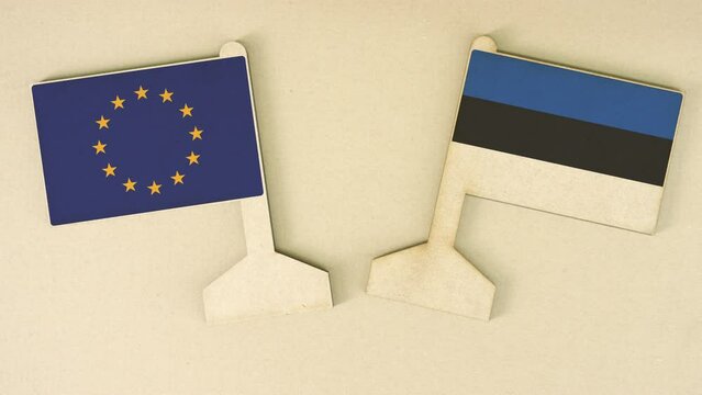 Flags of the European Union and Estonia made of recycled paper on the cardboard table