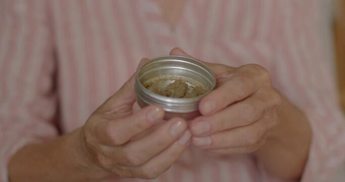 Close-up of the hands of an elderly woman with cbd cannabis. Allow medical marijuana use to treat pain, nausea symptoms. Sativa plant dried for inhalation. Therapeutic effects of cannabinoids.