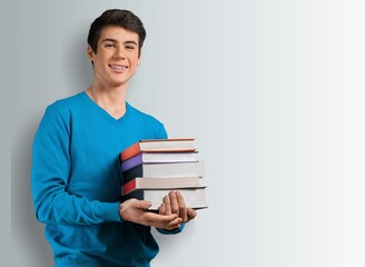 Portrait of happy teenager college or school boy holding books,