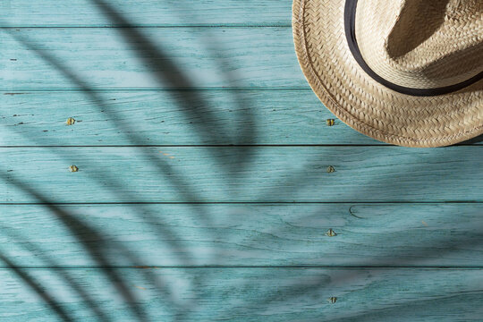 hat on wooden boards and palm tree shadow in vacation