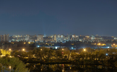 Night cityscape of the big city. Awesome bright, multi colored light at curfew on empty streets. Apartment buildings in bedroom community, commuter town area. Kyiv in last days in july 2022. Ukraine.
