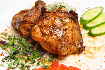 Pieces of fried chicken with vegetables on a white plate.