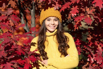 Teenager girl on autumn fall background. smiling kid in hat at autumn leaves on natural background