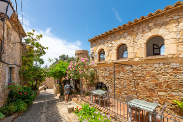 A picturesque cobblestone street with cafes and shops in the historic medieval hilltop 12th century...