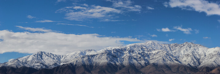 Fototapeta na wymiar Montañas nevadas con cielo azul y nubes