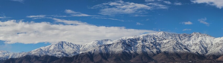 Montañas nevadas con cielo azul y nubes
