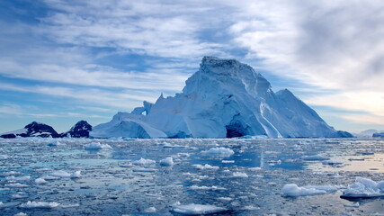Small bits of ice floating in Cierva Cove, in front of a massive iceberg, Antarctica