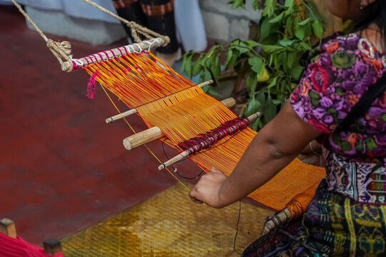 Closeup view of a Guatemalan Indigenous woman working in a traditional and typical handmade textile