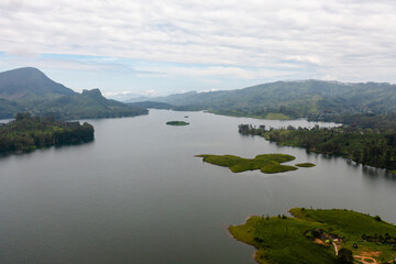 Aerial drone of lake in the mountains among tea estates and plantations Maskeliya, Sri Lanka.