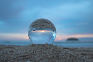 sweet blue sky in sunset above the island in crystal ball..stunning sunset over sea in a crystal ball on the beach. .A image for a unique and creative travel.