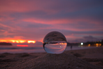 Fototapeta na wymiar amazing view of the sea and sky in beautiful sunset are unconventional and beautiful inside crystal ball. .A image for a unique and creative travel.