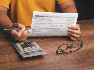 Tax day concept. Businessman using a tax form to complete individual income tax payment form