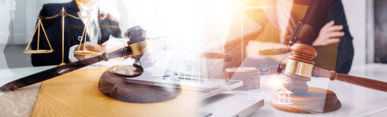 Justice and law concept.Male judge in a courtroom with the gavel, working with, computer and docking keyboard, eyeglasses, on table in morning light