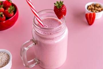strawberry smoothie, healthy shake with strawberry and milk on pink background.