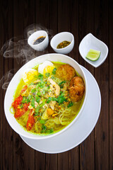 INDONESIAN CULINARY CHICKEN SOUP NOODLE WITH SLICE BOILING EGG AND FRIED MASHED POTATOS AS TOPPING