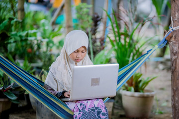 muslim girl homework in the garden