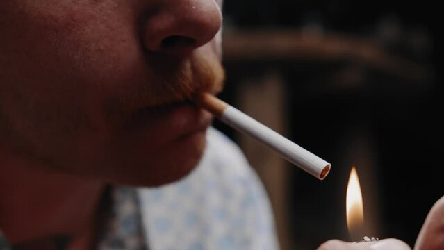 Cinematic close up shot of mechanic lighting up a cigarette 
