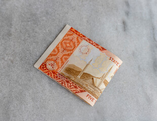 Pakistani currency bank notes of 5000 rupees isolated on marble background.
