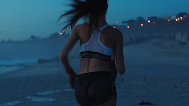 Active, fit and sporty athletes running, jogging and sprinting on a beach at sunset. Motivated, dedicated and fast women with stamina doing workout, exercise and training by the ocean from the back