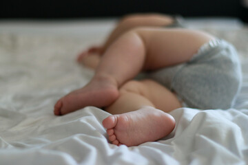 close up of sleeping baby boy 9 months old, bed with white sheets