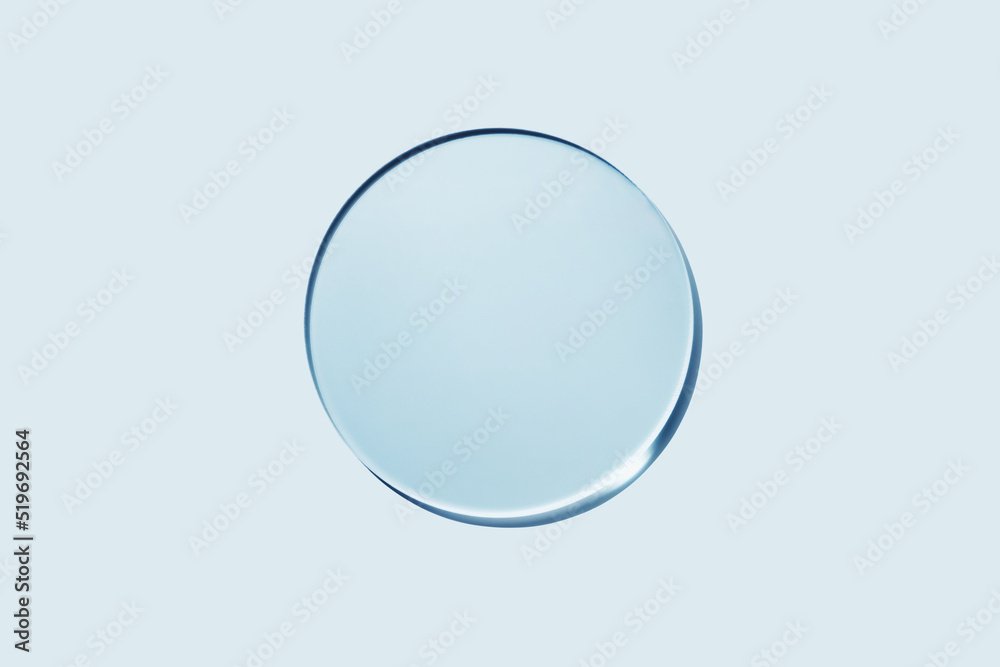 Wall mural Empty round petri dish or glass slide on blue background. Mockup for cosmetic or scientific product sample