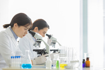 顕微鏡を覗く白衣の女性