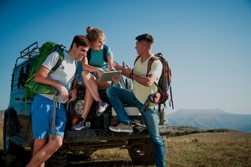 Team of hiking people using internet and tablet computer pc guide book