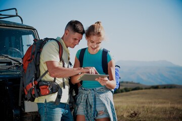 Team of hiking people using internet and tablet computer pc guide book