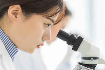 顕微鏡を覗く白衣の女性