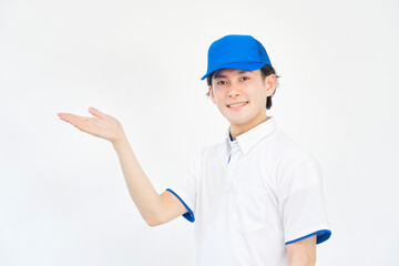 左側を掌で指すキャップとポロシャツのユニフォームの男性