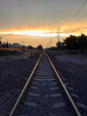 Fototapeta na wymiar Railroad tracks in the setting sun, train tracks at sunset