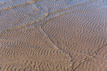 Fototapeta na wymiar Sand on the sea, shallow water and waves of Baltic sea.