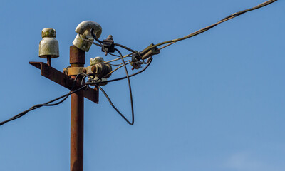 An old power pole supporting high voltage power lines