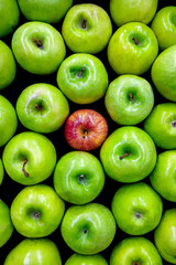 A red apple in the middle of green apples