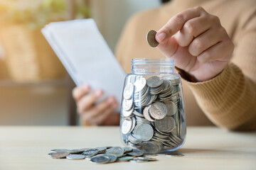 Woman with bills and savings coin jar to pay monthly. Bill payment or inflation concept with saving plan.