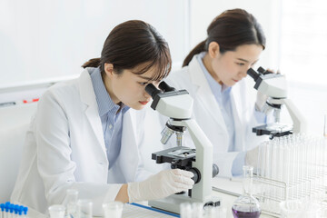顕微鏡を覗く白衣の女性