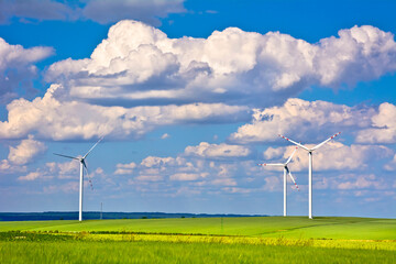 A wind turbines and green field on sunny day