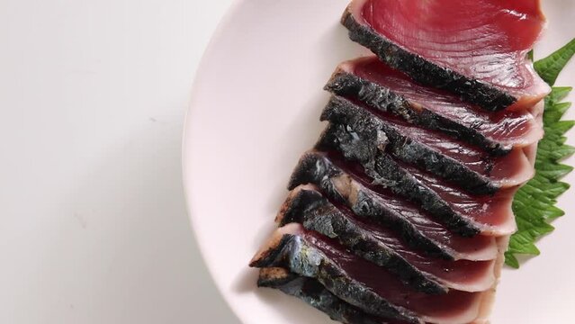Raw fish bonito with sashimi rotating on the table