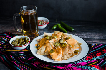 Mexican nachos chips with american cheese, beer and jalapeños in Mexico Latin America	