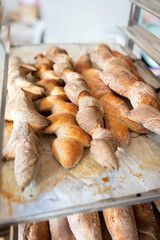 Finished French bread in the bakery on the racks. Baguettes, rustic bread. Vertical photo.