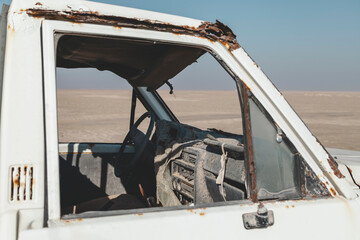 An old abandoned car in the desert in UAE, closeup view through the window