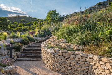 Rustic wooden stairs and stone wall in the garden.