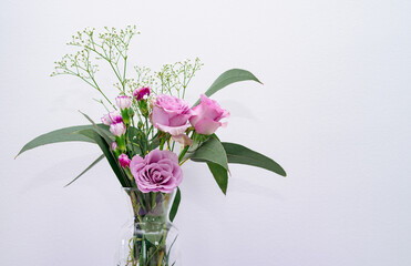 Bouquet of flowers in a vase with a white background. Copy space.