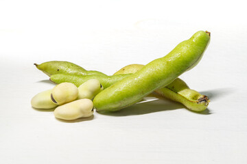 Fresh broad beans on a solid color background