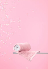 Towel on a pink background with bubbles.