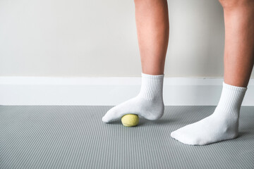 Myofascial release, Foot fascia massage with a ball, fitness, self-care, health, smart fitness. Myofascial relaxation of foot muscles with a massage ball on a mat at home, close-up