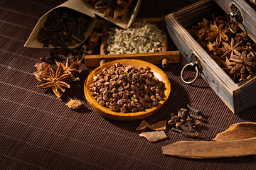 Chinese traditional seasoning five spice powder and raw materials on retro background
